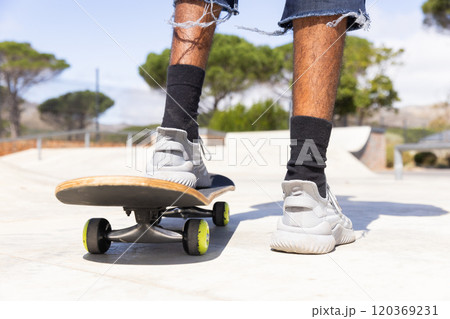Outdoors, Skateboarding, african american teenage boy in ripped jeans and sneakers enjoying activity Outdoors, Skateboarding, african american teenage boy in ripped jeans and sneakers enjoying activity 120369231