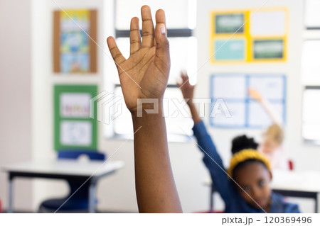 Raising hand in classroom, african american girl participating in school lesson actively Raising hand in classroom, african american girl participating in school lesson actively 120369496