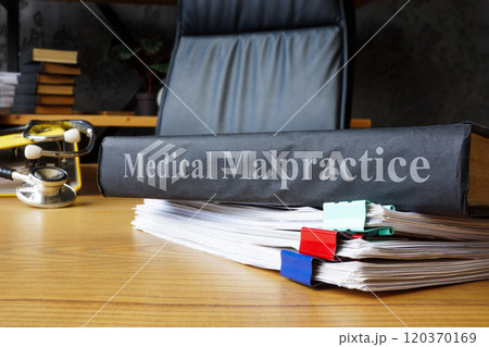 Medical malpractice documents on a table. 120370169