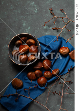 A bowl with edible chestnuts stands on a blue cloth A bowl with edible chestnuts stands on a blue cloth 120371246