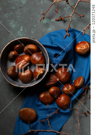 A bowl with edible chestnuts stands on a blue cloth A bowl with edible chestnuts stands on a blue cloth 120371248