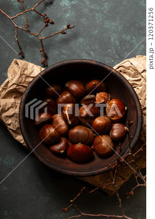 Edible chestnuts in a wooden bowl 120371256