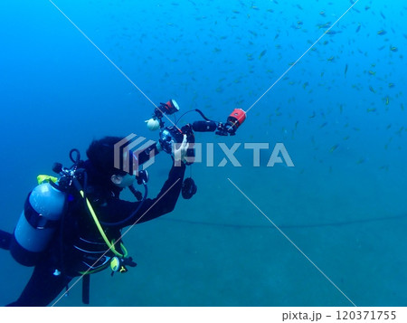 撮影中の水中カメラマンの男性 120371755
