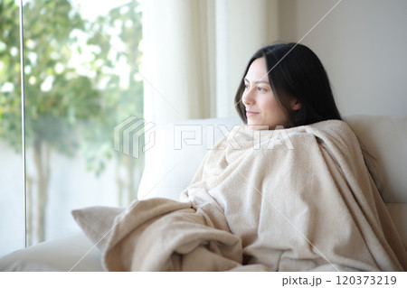 Relaxed woman resting covered with blanket at home Relaxed woman resting covered with blanket at home 120373219