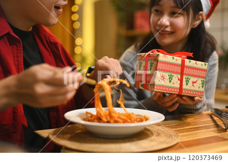 Cropped shot romantic couple enjoying pasta and exchanging gifts in a kitchen 120373469