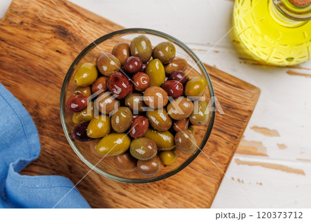 An assortment of various olives presented in a bowl, showcasing different colors, textures, and flavors 120373712
