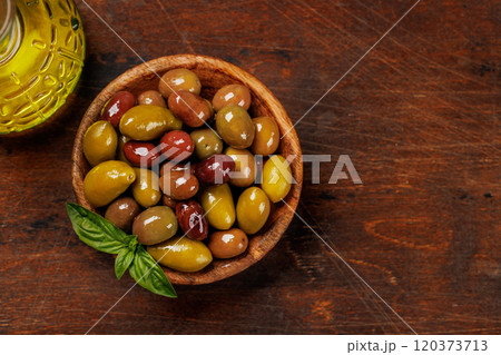An assortment of various olives presented in a bowl, showcasing different colors, textures, and flavors An assortment of various olives presented in a bowl, showcasing different colors, textures, and flavors 120373713