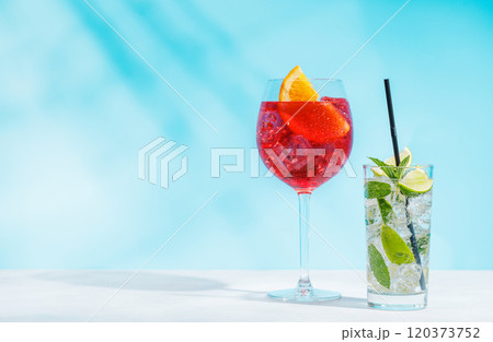 A variety of cocktails arranged on a table against a light blue background 120373752
