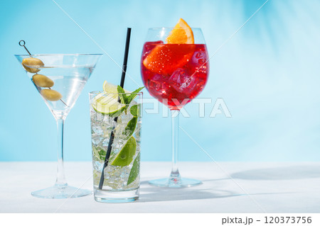 A variety of cocktails arranged on a table against a light blue background A variety of cocktails arranged on a table against a light blue background 120373756