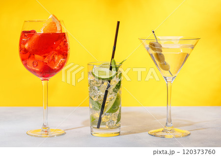 A variety of cocktails arranged on a table against a light yellow background A variety of cocktails arranged on a table against a light yellow background 120373760