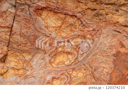Giant Causeway basalt rock texture with red hues formed by volcanic and iron rich processes 120374210
