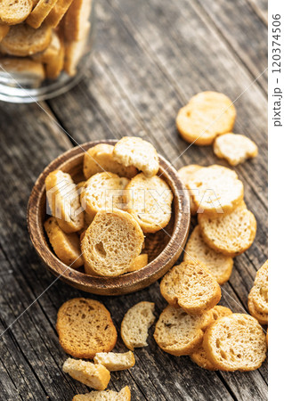 Sliced roasted bruschetta bread in bowl on wooden table. 120374506