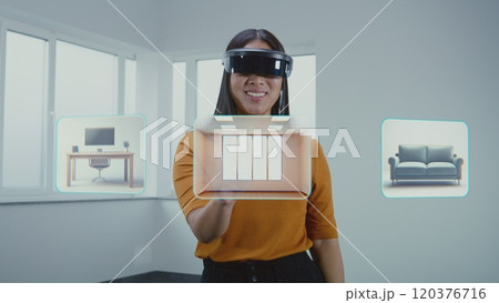 Asian female designer in VR headset creates interior in office room in 3D virtual space Asian female designer in VR headset creates interior in office room in 3D virtual space 120376716