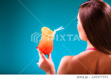 Girl s in swimsuit at poolside with cocktail glass sideview. Girl s in swimsuit at poolside with cocktail glass sideview. 120377351