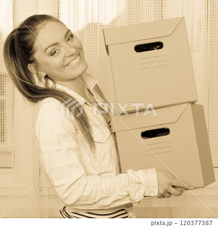 Happy woman moving into house carrying boxes. Happy woman moving into house carrying boxes. 120377387