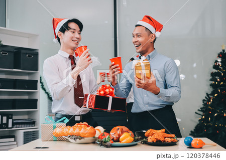 full length view of a group of business team wearing red Santa hat and exchange gift box together in the office for Christmas. full length view of a group of business team wearing red Santa hat and exchange gift box together in the office for Christmas. 120378446