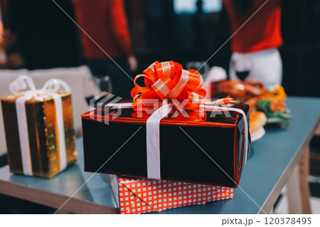Group of young Asian man and women as friends having fun at a New Year's celebration, holding gift boxes standing by Christmas tree decoration, midnight countdown Party at home with holiday season. Group of young Asian man and women as friends having fun at a New Year's celebration, holding gift boxes standing by Christmas tree decoration, midnight countdown Party at home with holiday season. 120378495