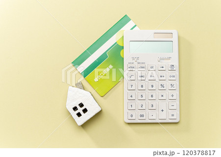 電卓と預金通帳とミニチュアの家 120378817
