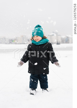 Boy child is standing in the snow, smiling and enjoying winter weather Boy child is standing in the snow, smiling and enjoying winter weather 120379258