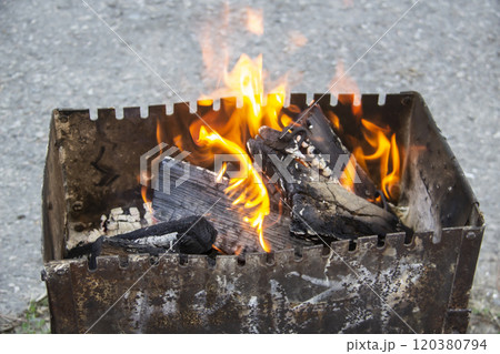 Barbecue grill mangal preparation with roaming fire outside building. Burns a firewood 120380794