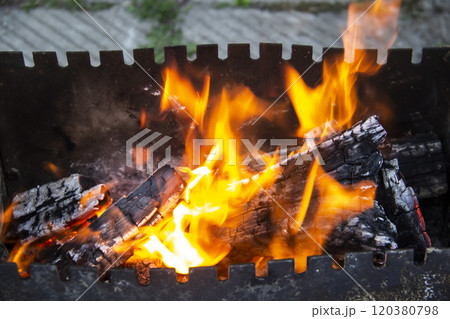 Barbecue grill mangal preparation with roaming fire outside building. Burns a firewood 120380798