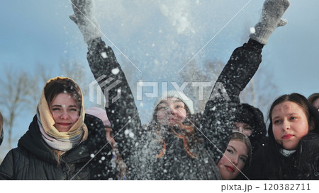 Happy schoolgirls enjoy tossing snow in the air, having a blast on a sunny winter day outside Happy schoolgirls enjoy tossing snow in the air, having a blast on a sunny winter day outside 120382711