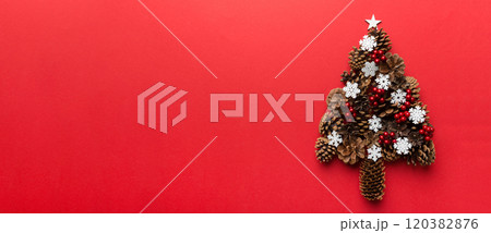 Christmas tree made from natural cones on colored background, view from above. New Year minimal concept with copy space Christmas tree made from natural cones on colored background, view from above. New Year minimal concept with copy space 120382876