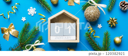 Christmas calendar 1 january. Christmas gift, fir branches, pine cones. Flat lay, top view. New Year decorations on a colored background 120382921