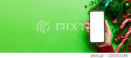 christmas mockup with space for text. christmas advertising, app template. hand holding phone with empty screen on table background. Happy New Year and Xmas Flat lay christmas mockup with space for text. christmas advertising, app template. hand holding phone with empty screen on table background. Happy New Year and Xmas Flat lay 120383186