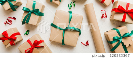 Christmas kraft gifts box with ribbon on colored background. Cozy Christmas still life, birthday or new year Christmas kraft gifts box with ribbon on colored background. Cozy Christmas still life, birthday or new year 120383367