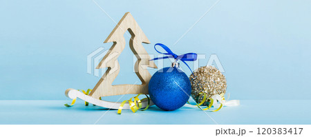 Christmas ball with decorative wooden tree on colored background. decoration bauble with ribbon bow with copy space Christmas ball with decorative wooden tree on colored background. decoration bauble with ribbon bow with copy space 120383417