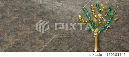 Creative flat lay composition with bottle of champagne and space for text on color background. Champagne bottle with colorful party streamers. holiday or christmas concept Creative flat lay composition with bottle of champagne and space for text on color background. Champagne bottle with colorful party streamers. holiday or christmas concept 120383545