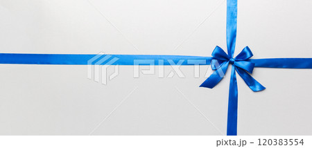 Top view of blue ribbon rolled and blue bow isolated on colored background. Flat lay with copy space Top view of blue ribbon rolled and blue bow isolated on colored background. Flat lay with copy space 120383554