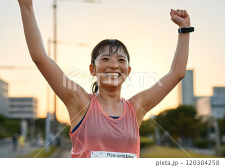 両手をあげる女子マラソン選手 120384258