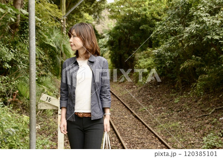 ローカル線の駅のホームでポーズをとる女性 ローカル線の駅のホームでポーズをとる女性 120385101