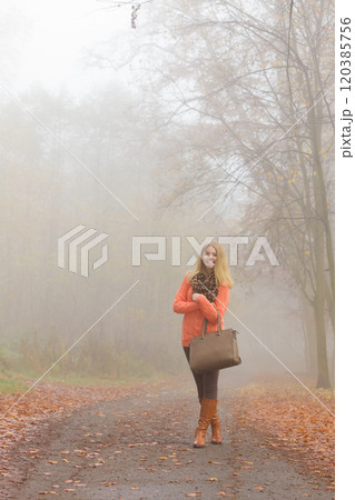 Happy fashion woman with handbag in autumn park Happy fashion woman with handbag in autumn park 120385756