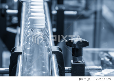 The filled drinking water bottles on the conveyor belt for filling process. The filled drinking water bottles on the conveyor belt for filling process. 120385829