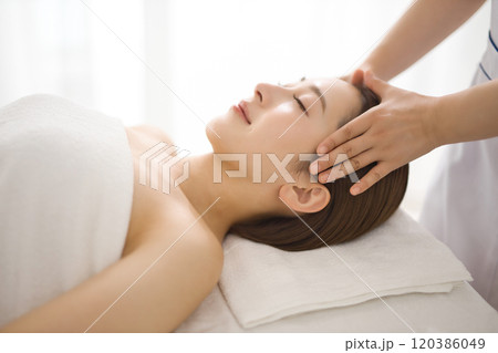 エステティシャンにマッサージを受ける女性 120386049