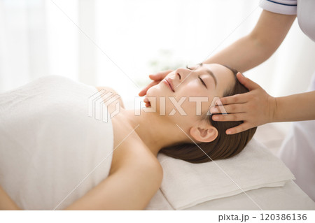 エステティシャンにマッサージを受ける女性 120386136