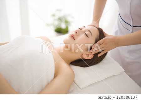 エステティシャンにマッサージを受ける女性 120386137