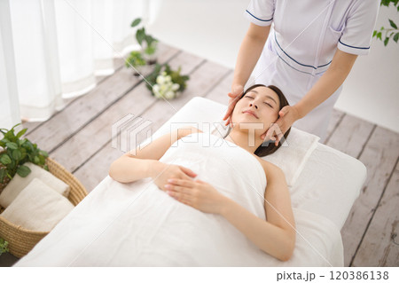 エステティシャンにマッサージを受ける女性 120386138