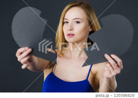 Young sad woman covered by broken heart. 120386820