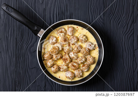 Ground poultry meatballs in a white cream gravy 120387697