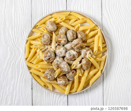 Ground chicken meatballs with penne pasta on plate 120387698