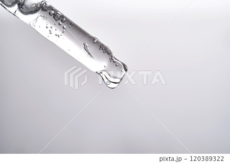 Pipette with facial serum pouring out of it on grey background. 120389322
