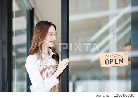 Cafe staff or owner opening the shop door, inviting customers with a friendly to start the day. 120390639