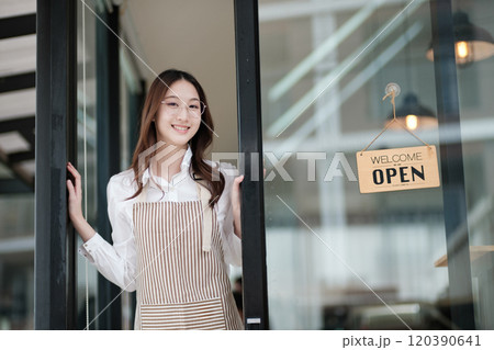 Cafe staff or owner opening the shop door, inviting customers with a friendly to start the day. 120390641
