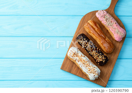 Assorted eclairs on a pastel top view Traditional French dessert 120390790