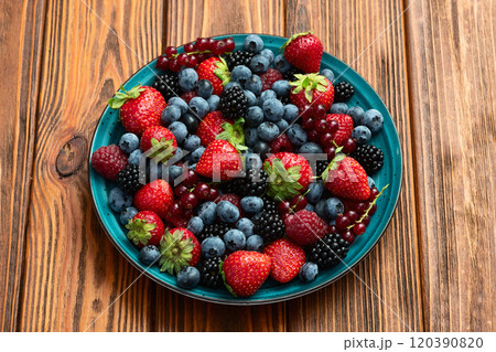 Mix of ripe colorful berries in bowl photography . Blueberry , strawberry , raspberry , blackberry and red currant . Top view 120390820