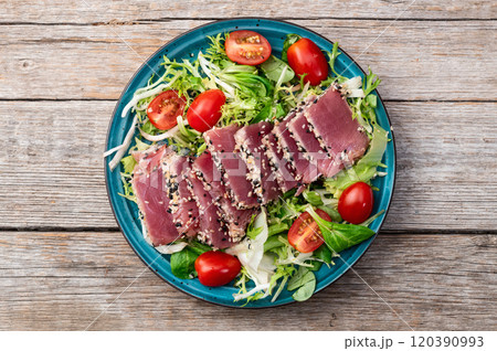 Salad with raw tuna , sesame and cherry tomatoes photography . Top view 120390993